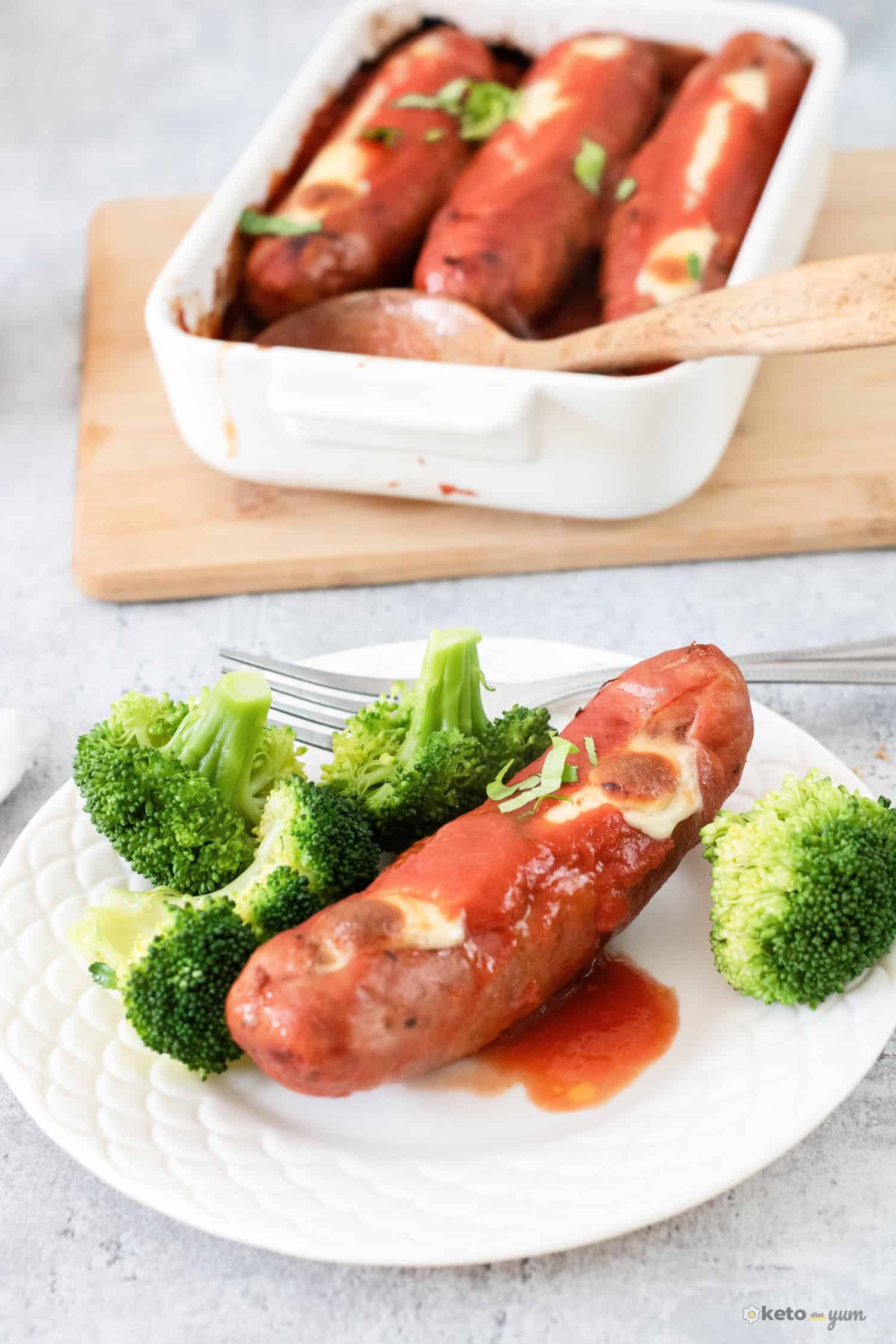 Stuffed sausage on a plate with steamed broccoli